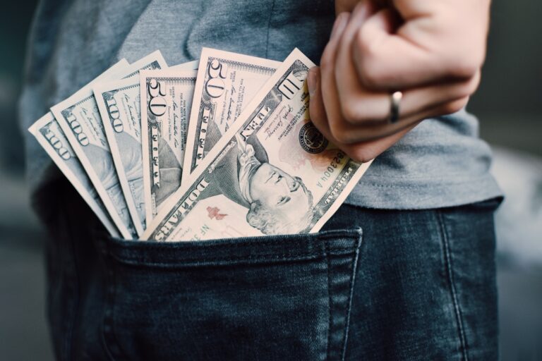 Man pulling out money of his jeans pocket